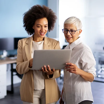 Happy-smiling-business-women-working-together-online-on-a-laptop-in-office